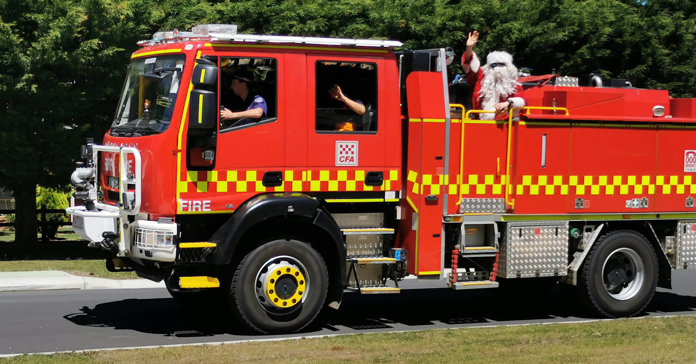 Santa waves from the back of a CFA fire truck.